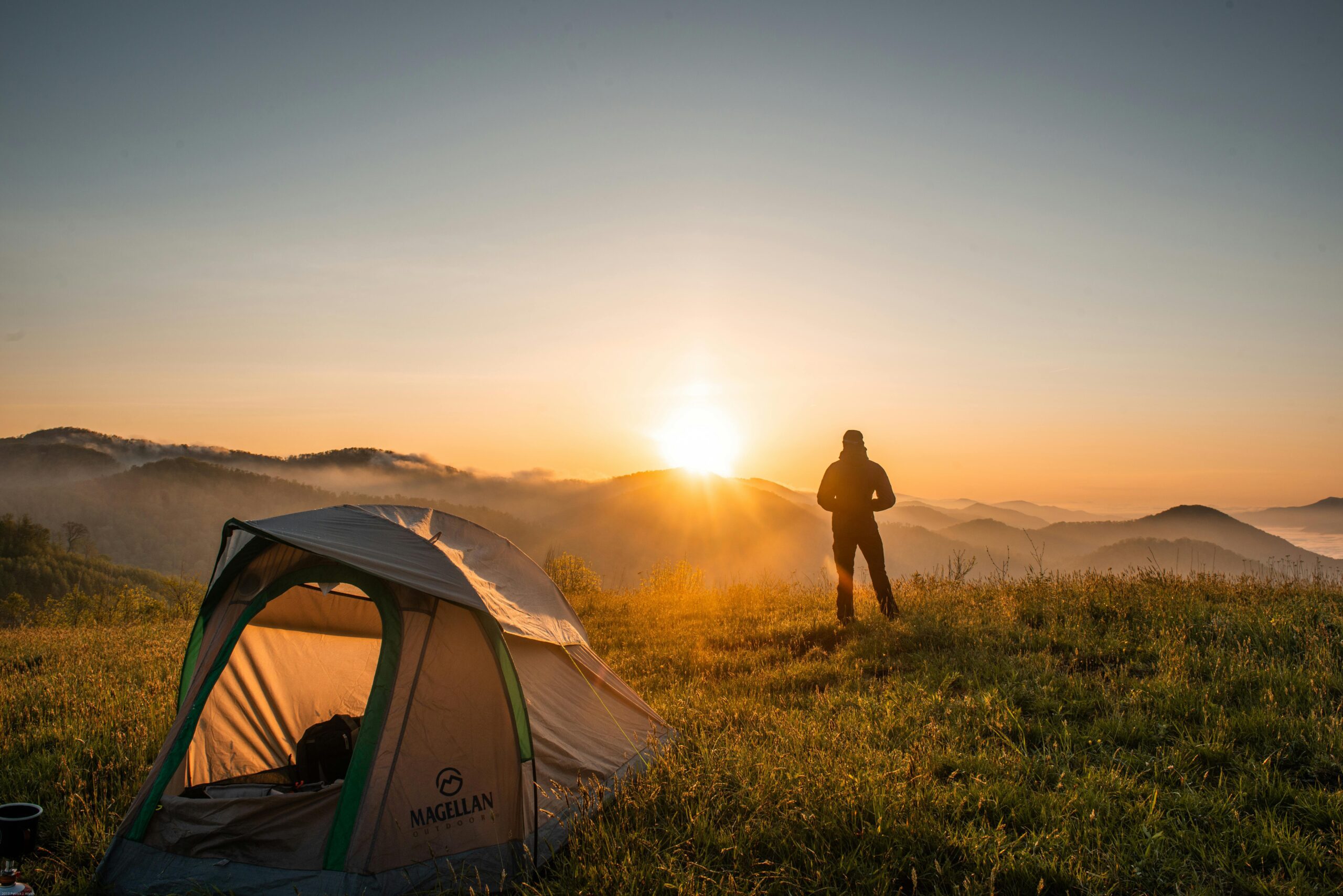 Survivalist man looking the horizon from his camp.